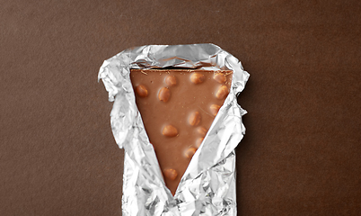 Image showing milk chocolate bar with nuts in foil wrapper