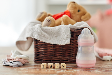 Image showing teddy bear toy in basket with baby things on table