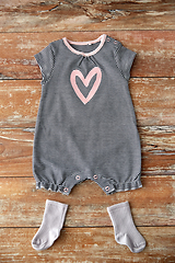 Image showing baby bodysuit and socks on wooden table