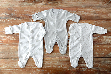 Image showing baby clothes set of bodysuits on wooden table