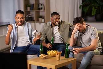 Image showing happy friends playing video games at home at night