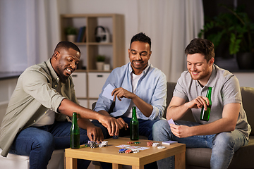 Image showing happy male friends playing cards at home at night