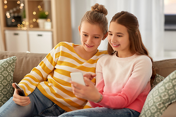 Image showing happy teenage girls with smartphones at home