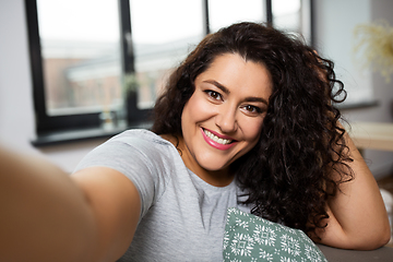 Image showing happy smiling young woman taking selfie at home