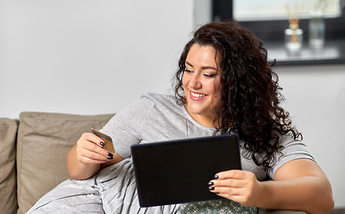 Image showing woman with tablet pc and credit card at home