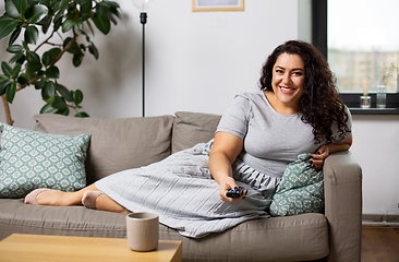 Image showing woman with remote control and watching tv at home