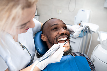 Image showing Young african-american man visiting dentist\'s office, smiling