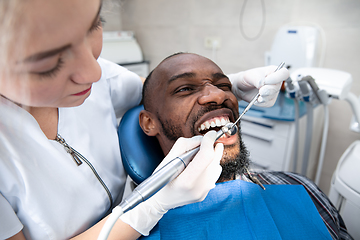 Image showing Young african-american man visiting dentist\'s office, smiling
