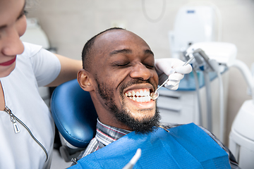 Image showing Young african-american man visiting dentist\'s office, smiling