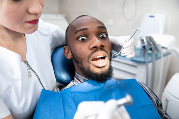 Image showing Young african-american man visiting dentist\'s office