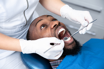 Image showing Young african-american man visiting dentist\'s office