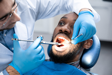 Image showing Young african-american man visiting dentist\'s office