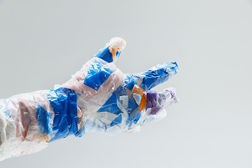 Image showing Big plastic hand made of garbage isolated on white studio background