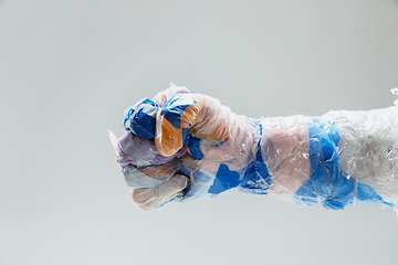 Image showing Big plastic hand made of garbage isolated on white studio background