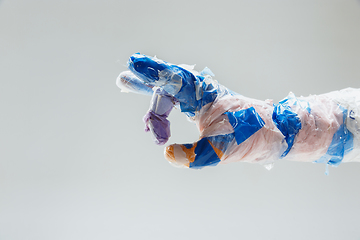 Image showing Big plastic hand made of garbage isolated on white studio background