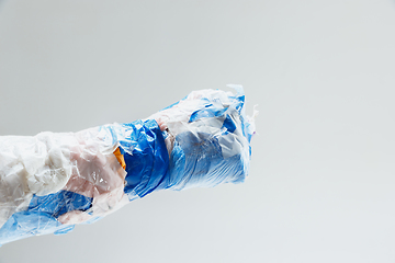 Image showing Big plastic hand made of garbage isolated on white studio background