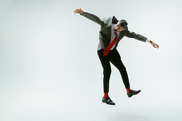 Image showing Young caucasian man moving flexible on white studio background