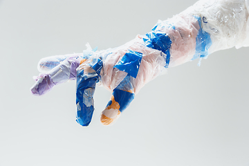 Image showing Big plastic hand made of garbage isolated on white studio background