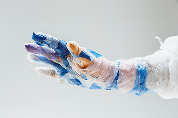 Image showing Big plastic hand made of garbage isolated on white studio background