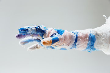 Image showing Big plastic hand made of garbage isolated on white studio background