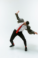 Image showing Young caucasian man moving flexible on white studio background