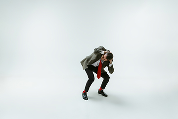 Image showing Young caucasian man moving flexible on white studio background