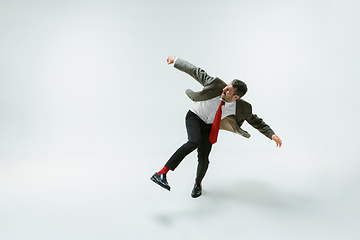 Image showing Young caucasian man moving flexible on white studio background