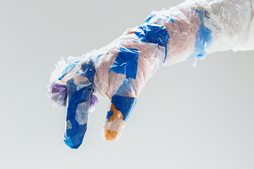 Image showing Big plastic hand made of garbage isolated on white studio background