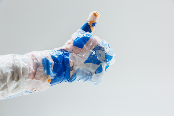 Image showing Big plastic hand made of garbage isolated on white studio background