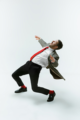 Image showing Young caucasian man moving flexible on white studio background