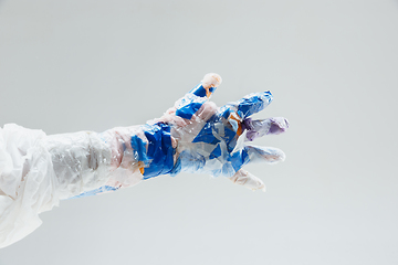 Image showing Big plastic hand made of garbage isolated on white studio background