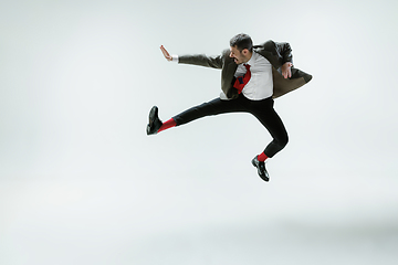 Image showing Young caucasian man moving flexible on white studio background