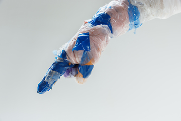 Image showing Big plastic hand made of garbage isolated on white studio background