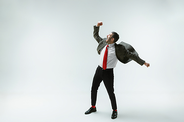 Image showing Young caucasian man moving flexible on white studio background