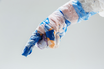 Image showing Big plastic hand made of garbage isolated on white studio background