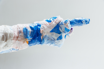 Image showing Big plastic hand made of garbage isolated on white studio background