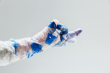 Image showing Big plastic hand made of garbage isolated on white studio background