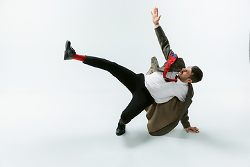 Image showing Young caucasian man moving flexible on white studio background