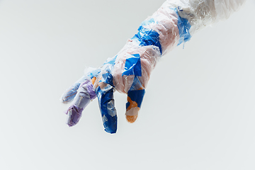 Image showing Big plastic hand made of garbage isolated on white studio background