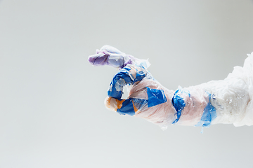 Image showing Big plastic hand made of garbage isolated on white studio background