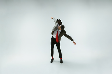 Image showing Young caucasian man moving flexible on white studio background