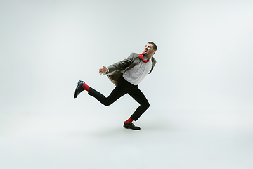 Image showing Young caucasian man moving flexible on white studio background