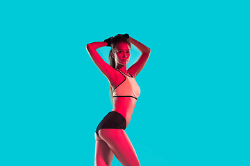 Image showing Muscular young female athlete on blue background