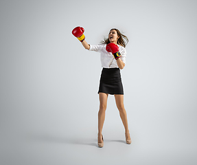 Image showing Caucasian woman in office clothes boxing isolated on grey studio background