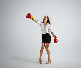 Image showing Caucasian woman in office clothes boxing isolated on grey studio background