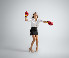 Image showing Caucasian woman in office clothes boxing isolated on grey studio background