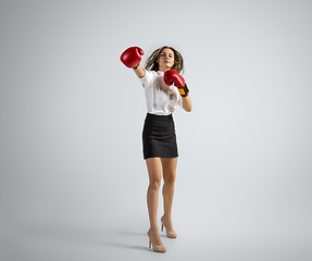 Image showing Caucasian woman in office clothes boxing isolated on grey studio background