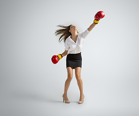 Image showing Caucasian woman in office clothes boxing isolated on grey studio background