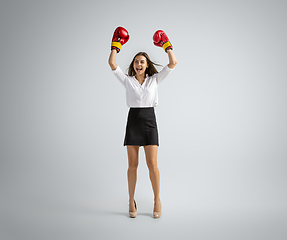 Image showing Caucasian woman in office clothes boxing isolated on grey studio background