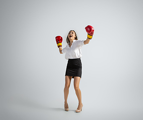 Image showing Caucasian woman in office clothes boxing isolated on grey studio background